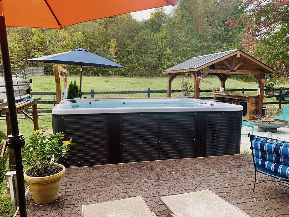 Buffalo pools and spas installed showing setup with umbrellas and pavilion.