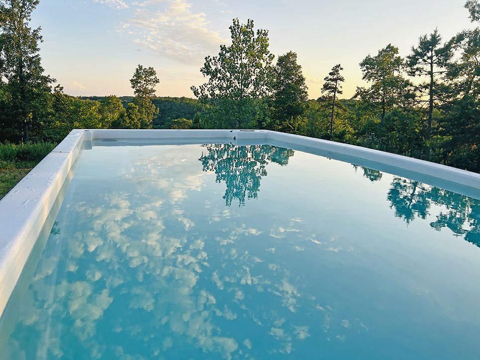 Buffalo pools and spas installed showing view of trees and beyond a mountain.